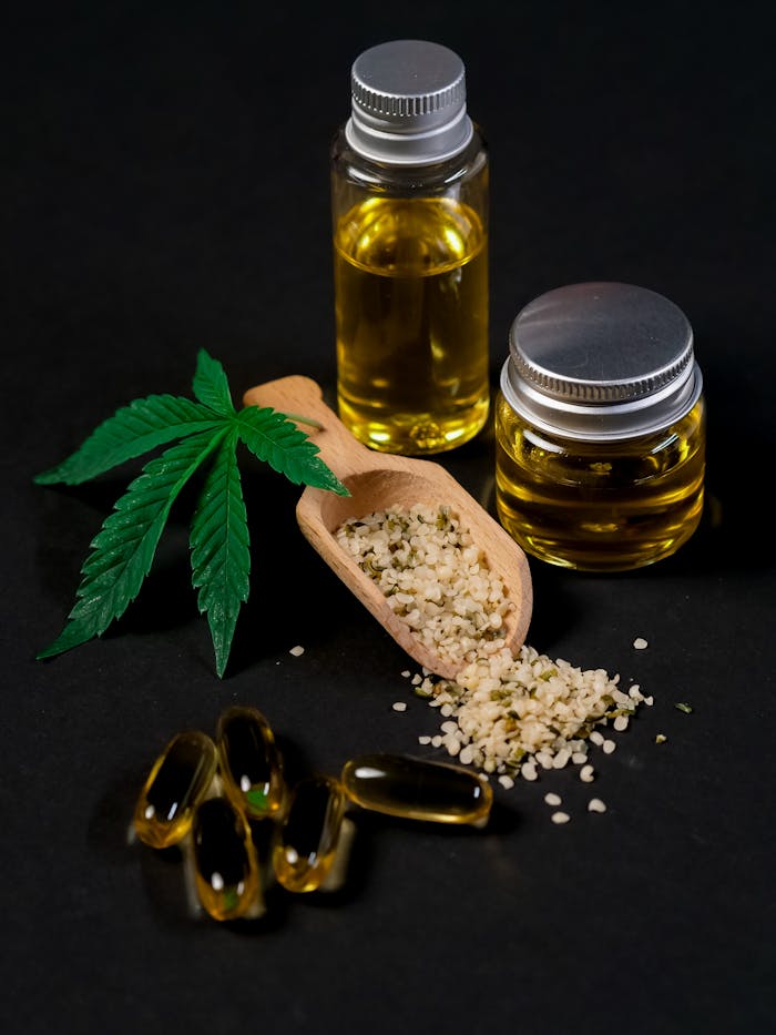hero-img-02 A set of CBD products including oil, capsules, hemp seeds, and a cannabis leaf, presented on a dark backdrop.