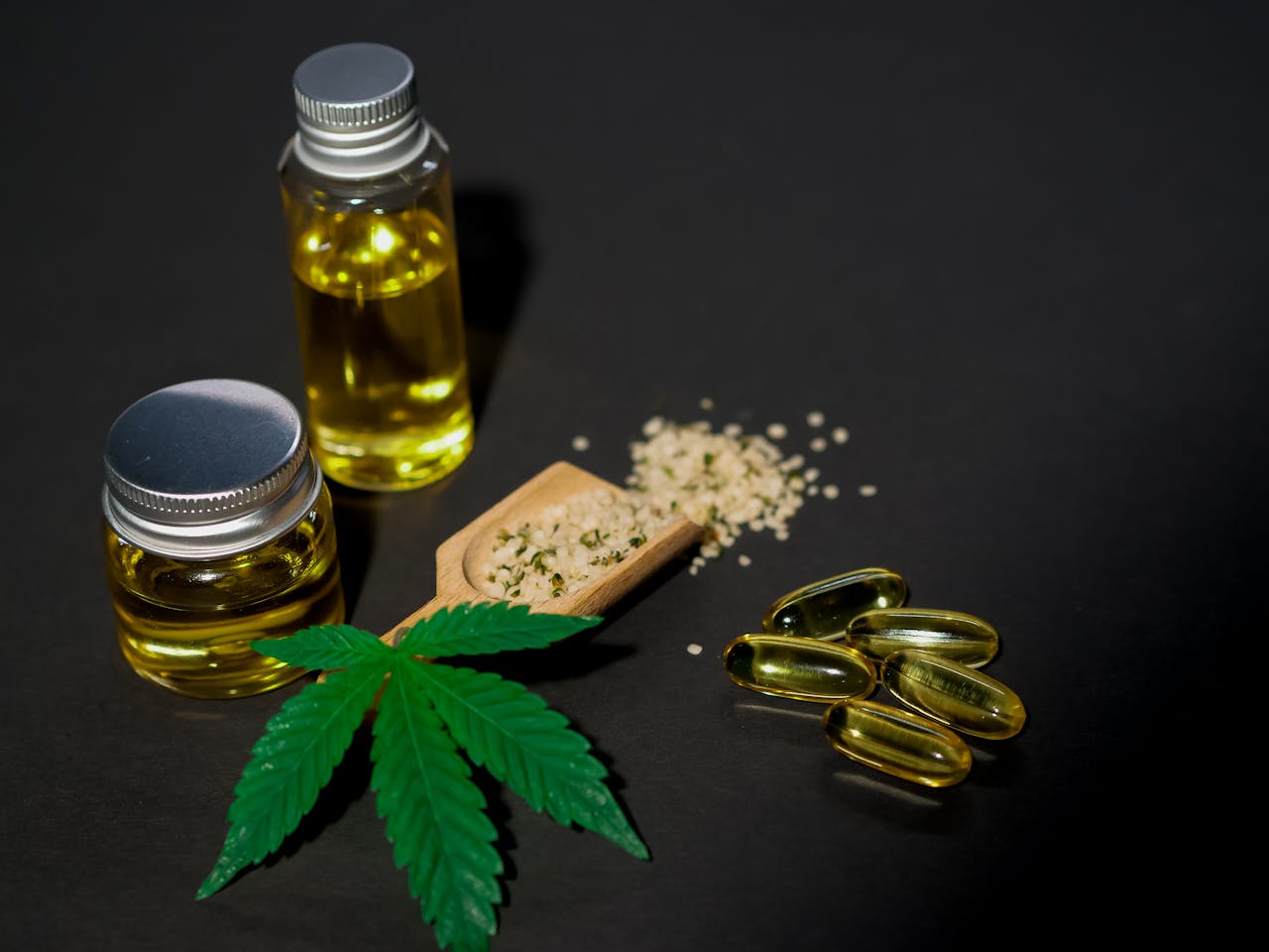 hero-img-01 High-quality image featuring cannabis oil, seeds, leaves, and capsules on a dark background.